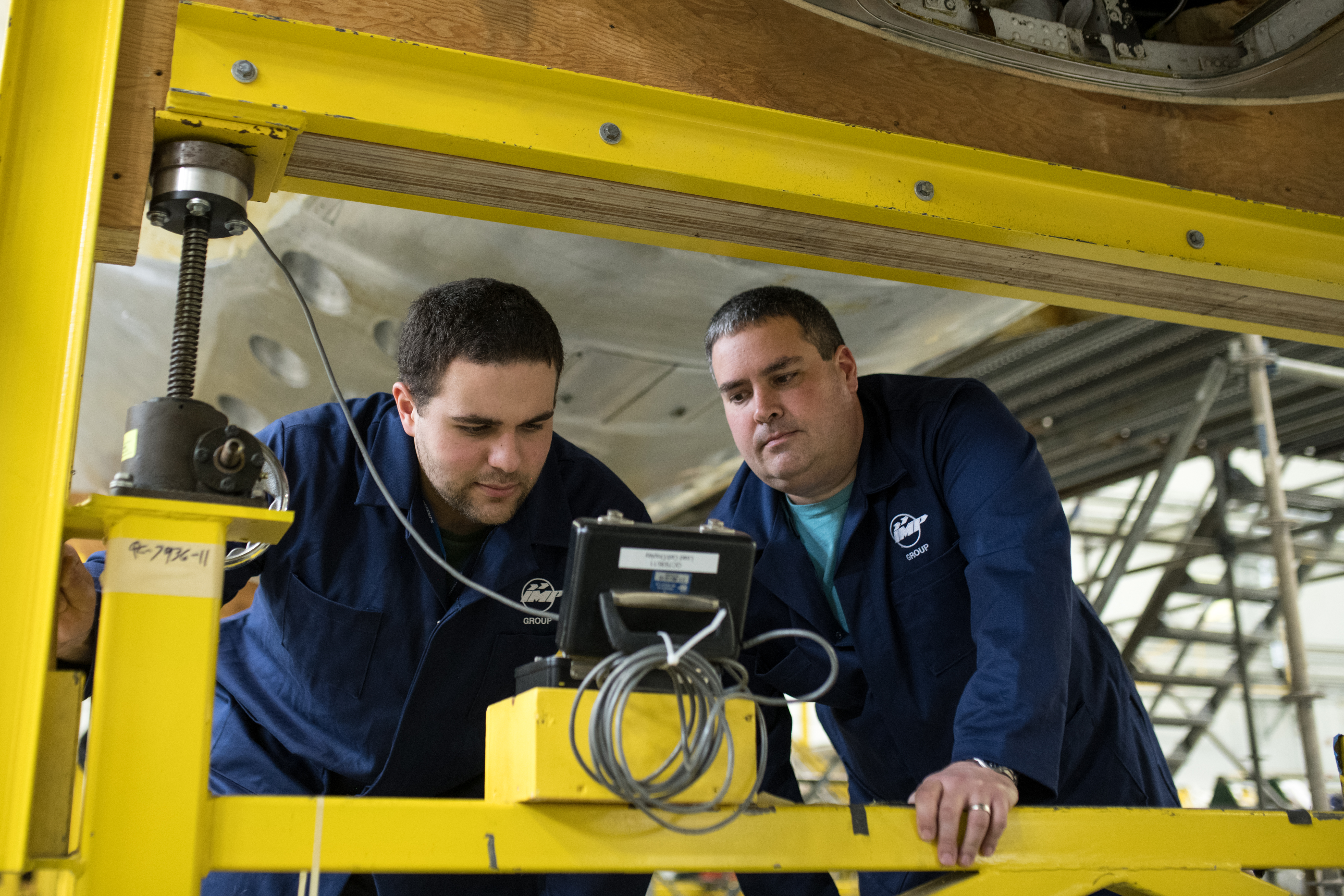 Technicians performing critical inspection on aircraft