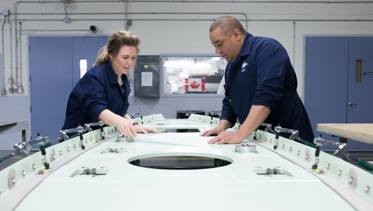 Engineers performing aircraft component repairs