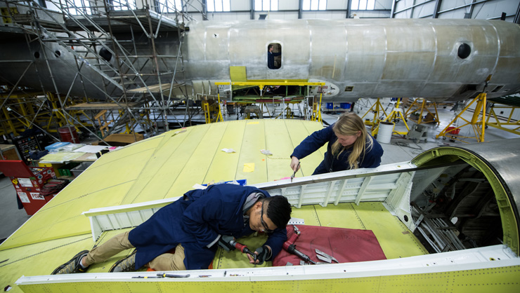 Aircraft technicians working on the wing of an aircraft