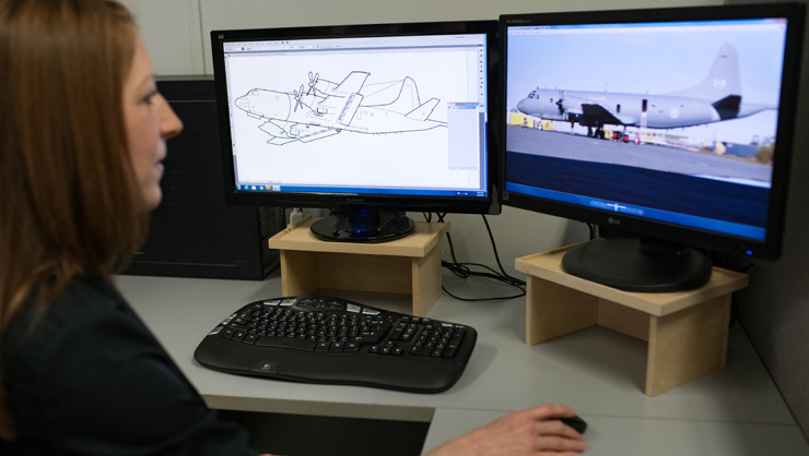 Engineer reviewing a technical draft of an aircraft on the computer